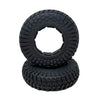 Two black off-road tires with tread pattern on a transparent background