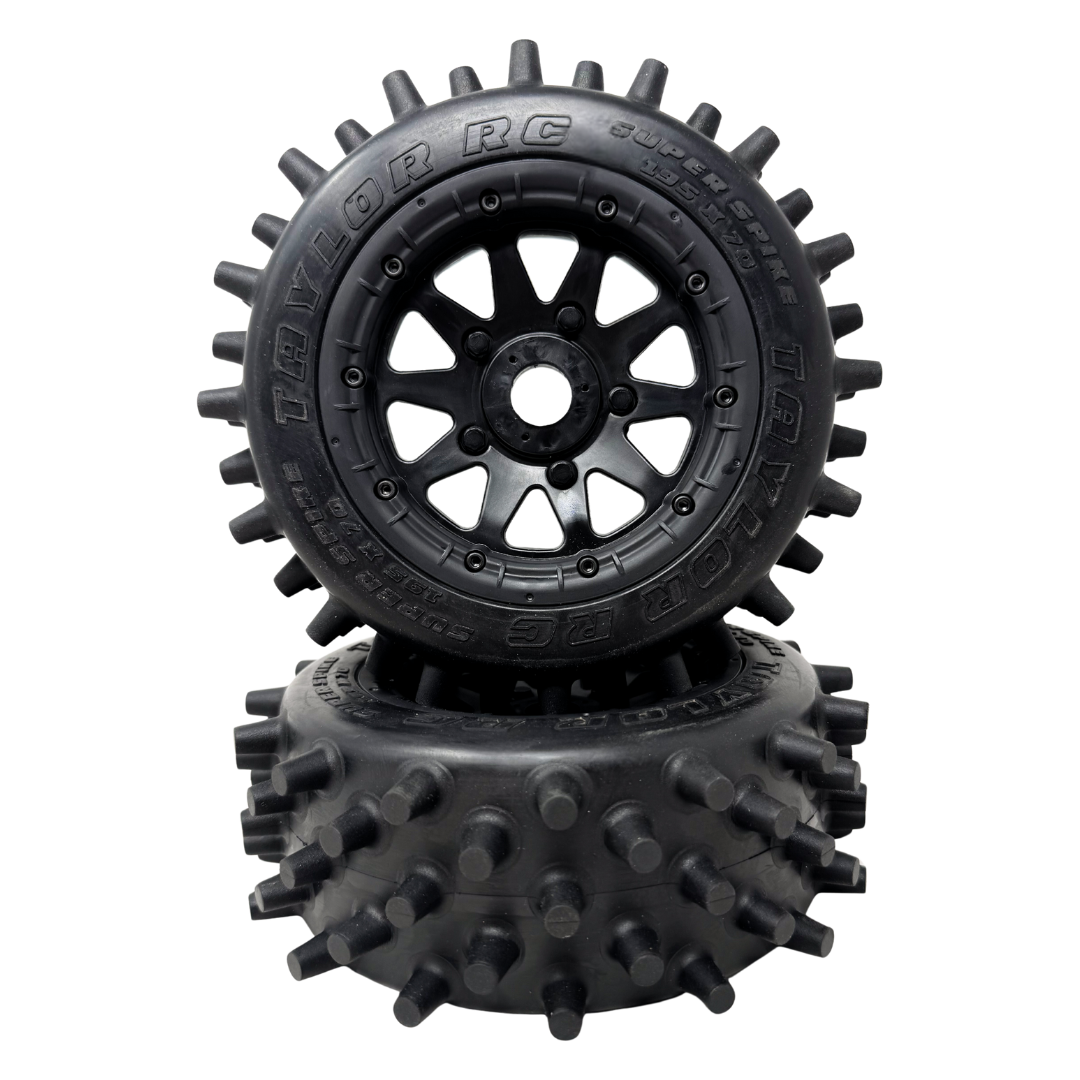 Black RC tire with spiky tread pattern on a white background